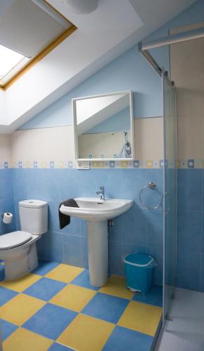 a bathroom with a sink and a toilet and a mirror at Apartamentos Playas de Noja in Noja