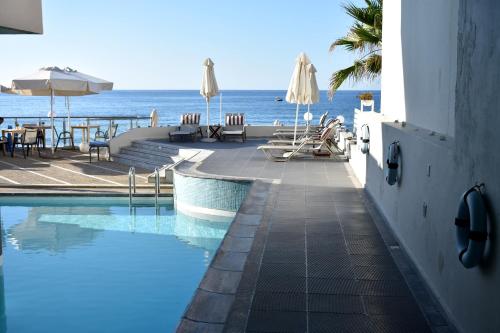 a swimming pool with a view of the ocean at Filoxenia Beach Hotel in Rethymno Town