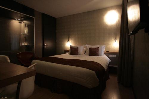 a hotel room with a large bed and lights at Amosa Liège City Centre Hotel in Liège
