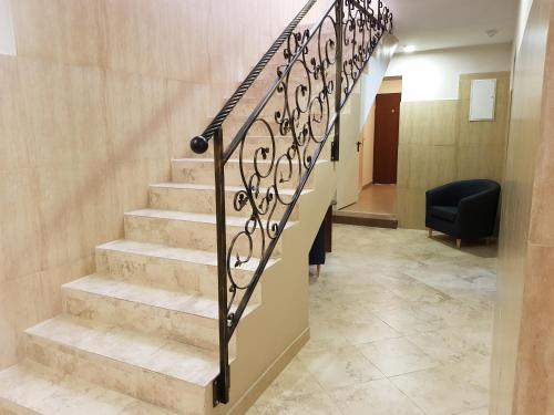 a staircase in a lobby with a black railing at Marcus in Bydgoszcz