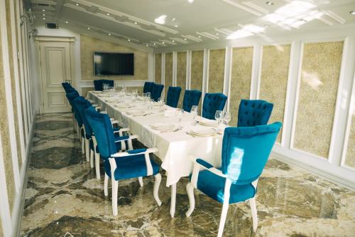 une salle de conférence avec une grande table et des chaises bleues dans l'établissement Emerald Suite Hotel, à Baku