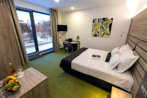 ein Hotelzimmer mit einem Bett und einem Tisch mit Obst darauf in der Unterkunft Hotel Castellum in Čakovec
