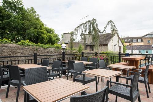 a patio with tables and chairs and a roller coaster at The Old Borough Hotel - Wetherspoon in Swords