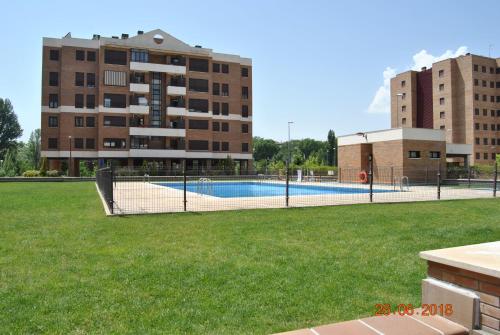 a swimming pool in a park next to a building at Huertas de la Alameda in Cuenca