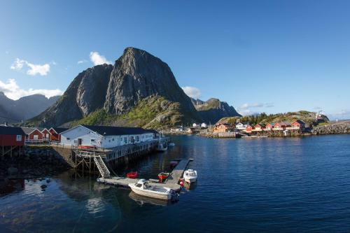 two boats are docked at a dock in a body of water at Eliassen Rorbuer in Reine