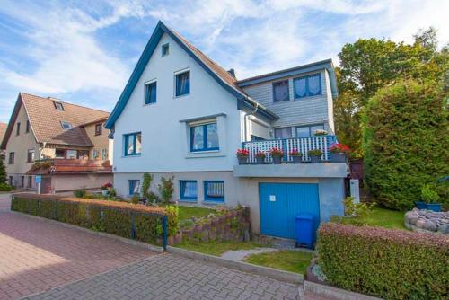 a large white house with a blue garage at Ferienwohnung Gentzen in Baabe