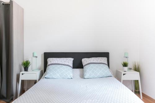 een slaapkamer met een bed met twee witte nachtkastjes bij Flamingo appartement Diderot 2 Center in Béziers
