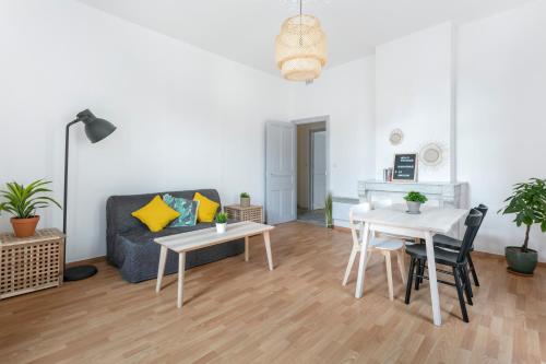 een woonkamer met een bank en een tafel en stoelen bij Flamingo appartement Diderot 2 Center in Béziers