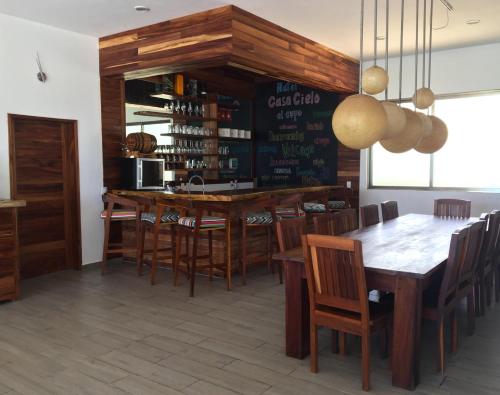 a dining room with a bar and a table and chairs at Hotel La Casa Cielo solo adultos in El Cuyo
