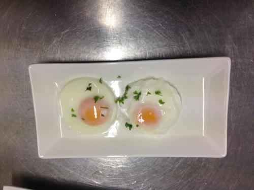 two eggs on a white plate on a table at Kylemore Pass Hotel in Letterfrack