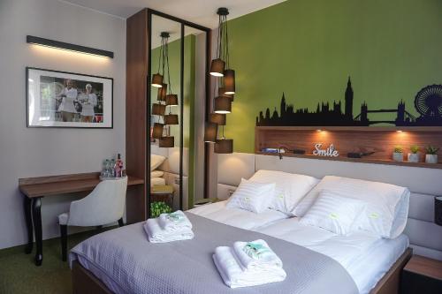 a hotel room with a bed with towels on it at AGA Tenis Apartments by Radwańska in Krakow
