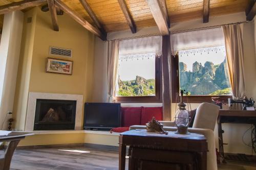 a living room with a fireplace and a television at Tasos House in Kalabaka
