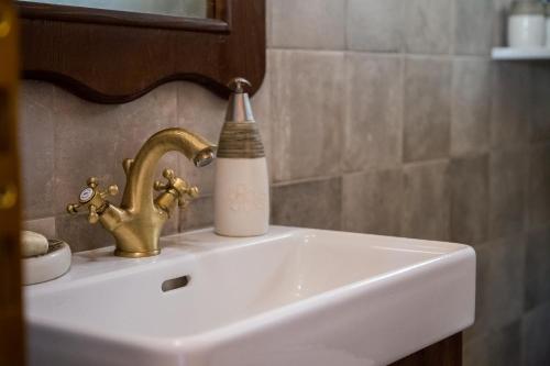 a bathroom sink with a faucet and a bottle on it at Tasos House in Kalabaka