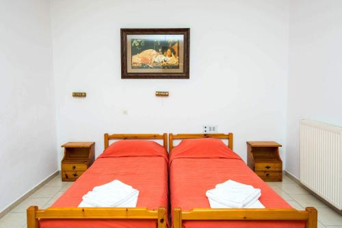 a bedroom with two beds and a picture on the wall at Erato Hotel Apartments in Rethymno