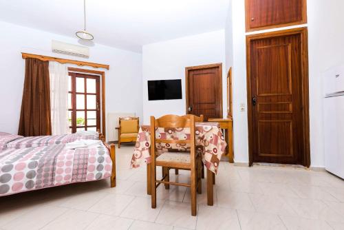a bedroom with a bed and a chair and a tv at Erato Hotel Apartments in Rethymno
