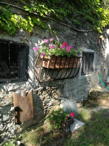 a stone wall with a planter with flowers in it at Prà de Mandè in Viano