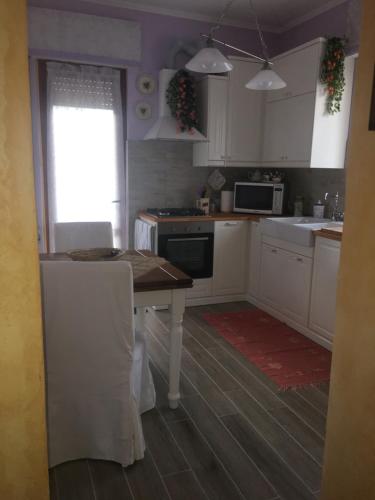 a kitchen with white cabinets and a wooden table at Lovely Versilia Tuscany in Torre del Lago Puccini