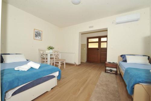 a bedroom with two beds and a table with a table at Apartments Olive in Kotor