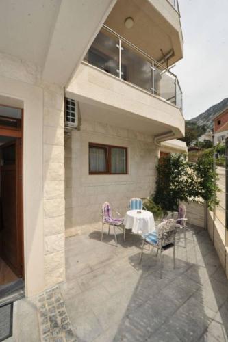 a patio with chairs and a table in front of a building at Apartments Olive in Kotor