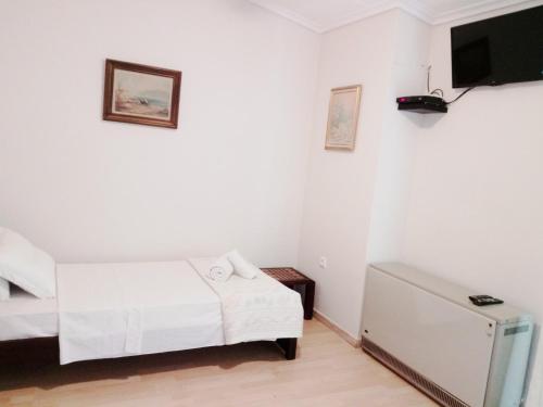 a bedroom with a bed and a tv on the wall at Sweet Maisonette in Perea