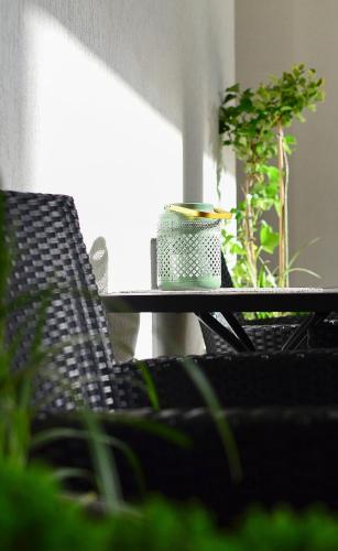 a table with two chairs and a cup on it at AGA Tenis Apartments by Radwańska in Krakow