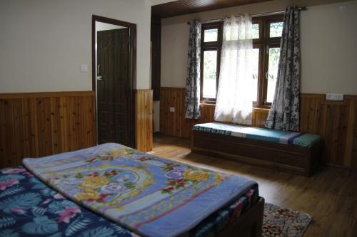 1 dormitorio con cama, ventana y banco en Vamoose Gomethang Homestay, en Sosing