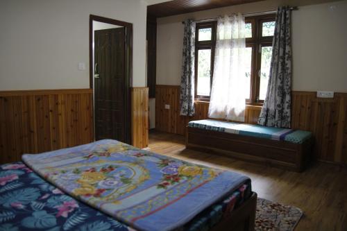 una camera con letto, finestra e panca di Vamoose Gomethang Homestay a Sosing