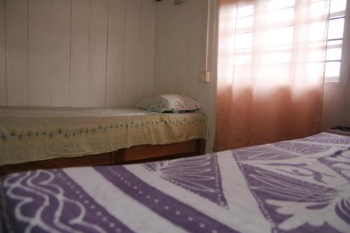 two beds in a small room with a window at Vamoose Gomethang Homestay in Sosing
