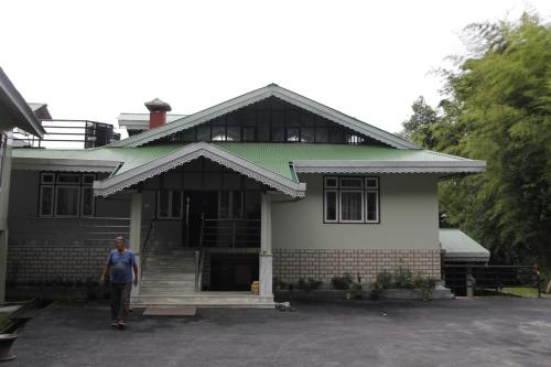 a person standing in front of a house at Vamoose Gomethang Homestay in Sosing
