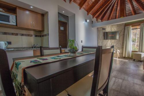 a kitchen and dining room with a table and chairs at Bahia Paraiso Apart & Suites in San Carlos de Bariloche