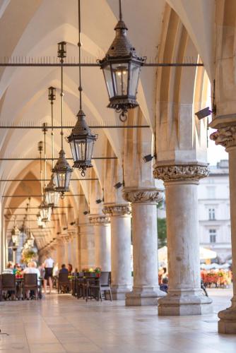 an arcade with lights and tables and chairs at AGA Tenis Apartments by Radwańska in Krakow