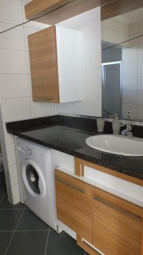 a bathroom with a sink and a washing machine at Taurus Residences 2 in Kemer