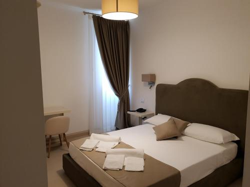 a bedroom with a bed with white sheets and pillows at Villa Natia in Mottola