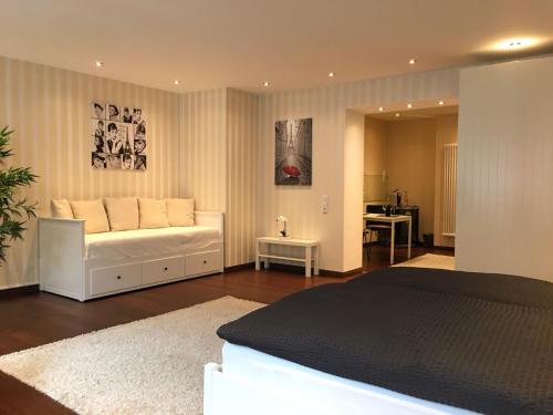 Una sala de estar con un sofá blanco y una mesa. en Aparthotel C'est la vie, en Saarlouis