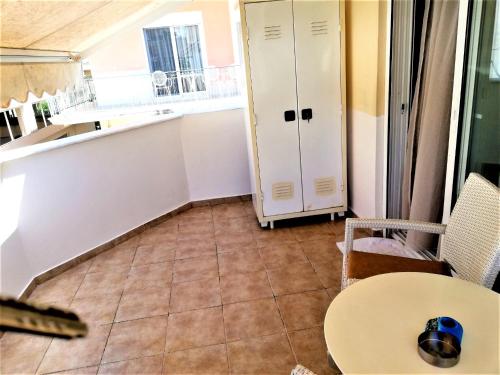 a room with a table and a kitchen with a window at Kalamata Downtown Apartment in Kalamata