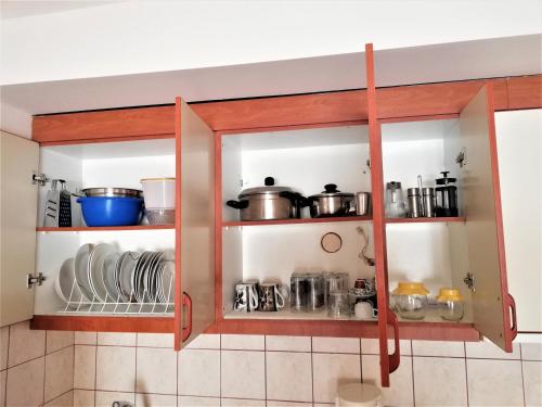 a kitchen cabinet filled with pots and pans at Kalamata Downtown Apartment in Kalamata