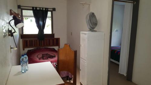a small room with a table and a refrigerator at La Casa de Don David in El Remate
