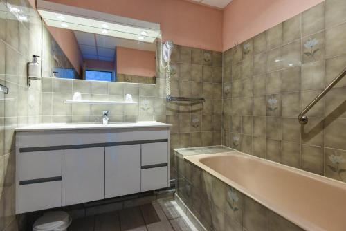 a bathroom with a sink and a bath tub at Hotel des Pyrénées in Font-Romeu