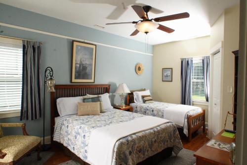 Seven Oaks Inn Bed and Breakfast في هاي بوينت: غرفة نوم بسريرين ومروحة سقف