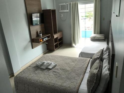 Habitación de hotel con 2 camas y espejo en Pousada Fernandes, en Arraial do Cabo