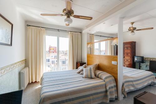 1 dormitorio con cama y ventana grande en Mallorca Boutique Hotel, en Malgrat de Mar