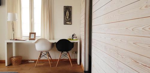 a room with a desk and two chairs next to a wall at Hotel Au Nom De Dieu in Dilsen-Stokkem