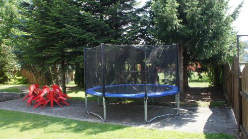 a playground with a blue trampoline in a yard at Apartmany Agatha in Loučná nad Desnou