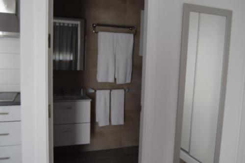 a bathroom with white towels hanging on a wall at Alojamientos Alma in Conil de la Frontera