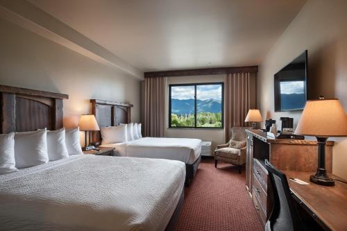 a hotel room with two beds and a window at Glacier International Lodge in Kalispell