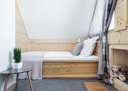 a small bedroom with a bed with a window at Stylowa Chata in Zakopane