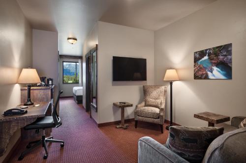 a hotel room with a desk and a chair at Glacier International Lodge in Kalispell