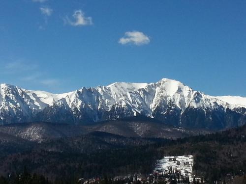 a mountain range with snow covered mountains in the distance at Hotel Belvedere in Predeal