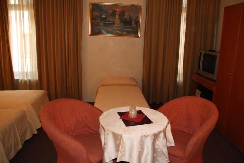a hotel room with a table and two chairs and a bed at Auberge Gaglioti in Luxembourg