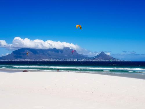 a group of people flying kites on a beach at Heaven on Earth - Blouberg Beachfront Self-catering Apartment in Bloubergstrand